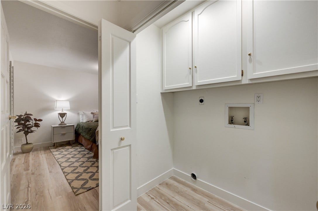 3005 Plaza De Rosa, Las Vegas, NV 89102 A dedicated laundry closet offers overhead cabinetry and wood-look flooring near the bedroom.