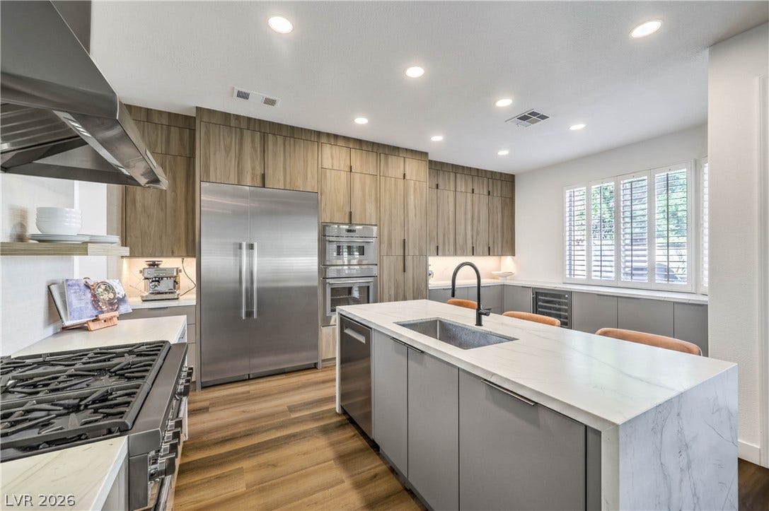 1863 Bogey Way, Henderson, NV 89074 Sleek modern cabinetry and integrated appliances frame a central island with waterfall stone countertops.