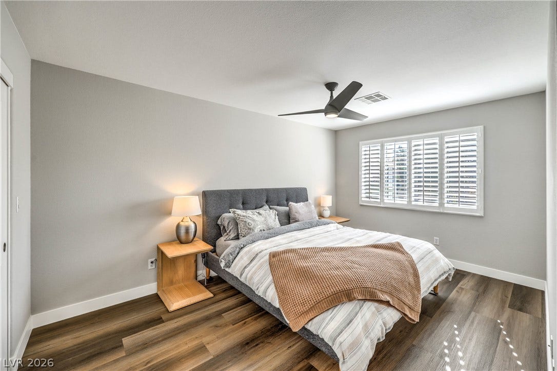 1863 Bogey Way, Henderson, NV 89074 Rich wood plank flooring sets a warm foundation in this inviting bedroom space.