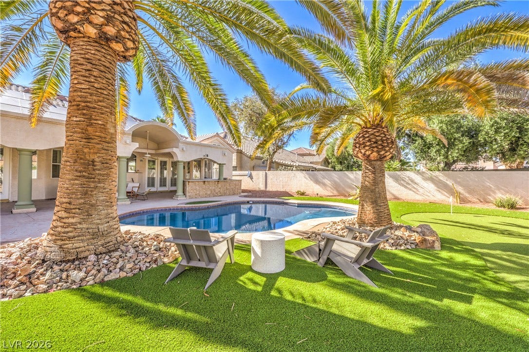 1863 Bogey Way, Henderson, NV 89074 Towering palm trees flank a sparkling swimming pool in this private backyard oasis.