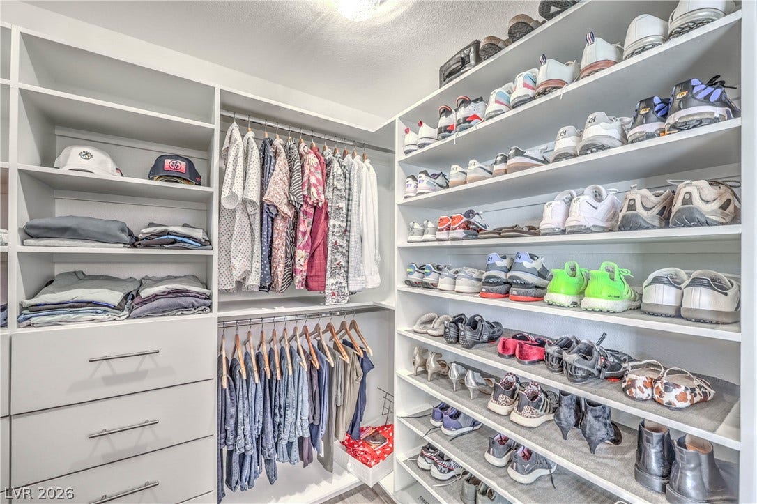 1863 Bogey Way, Henderson, NV 89074 Floor-to-ceiling custom shelving and integrated dresser drawers maximize storage in this walk-in closet.