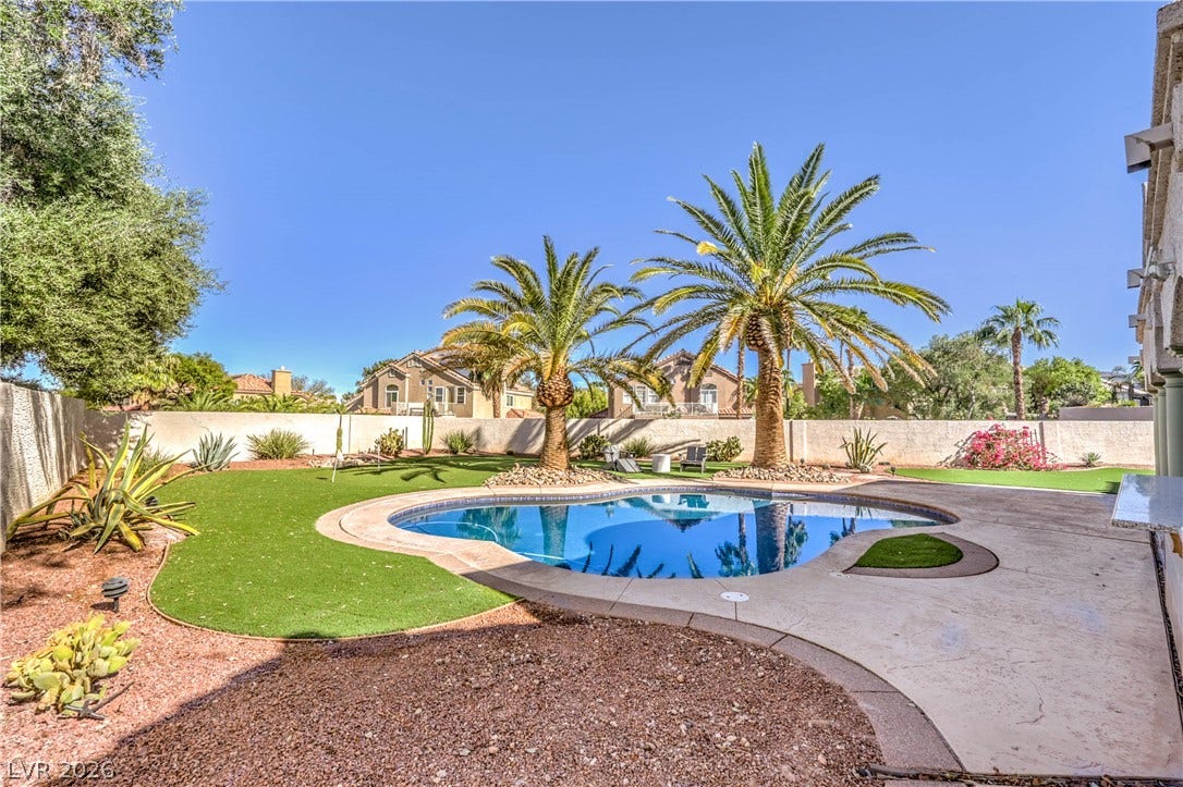 1863 Bogey Way, Henderson, NV 89074 Mature palm trees frame a sparkling pool set within a beautifully landscaped backyard retreat.