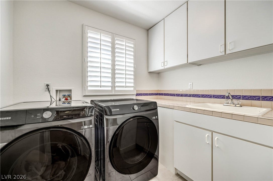 1863 Bogey Way, Henderson, NV 89074 Functional workspace features extensive storage cabinetry alongside tile countertops and built-in washing amenities.