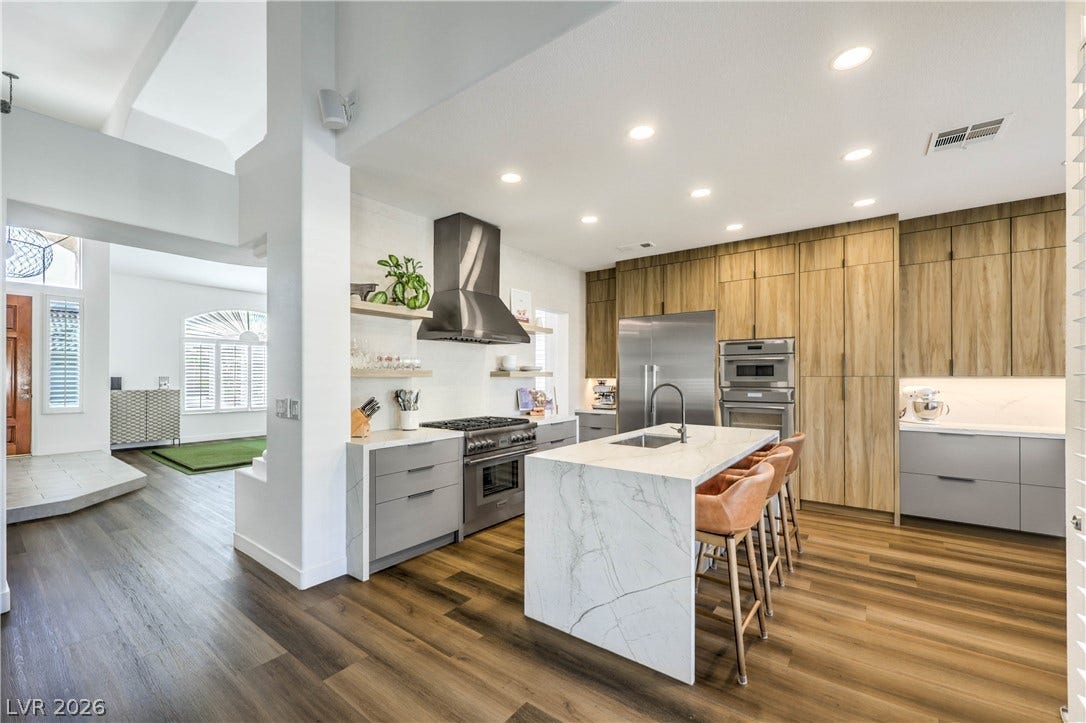 1863 Bogey Way, Henderson, NV 89074 Gleaming wood floors anchor a culinary workspace defined by sleek marble counters and integrated appliances.