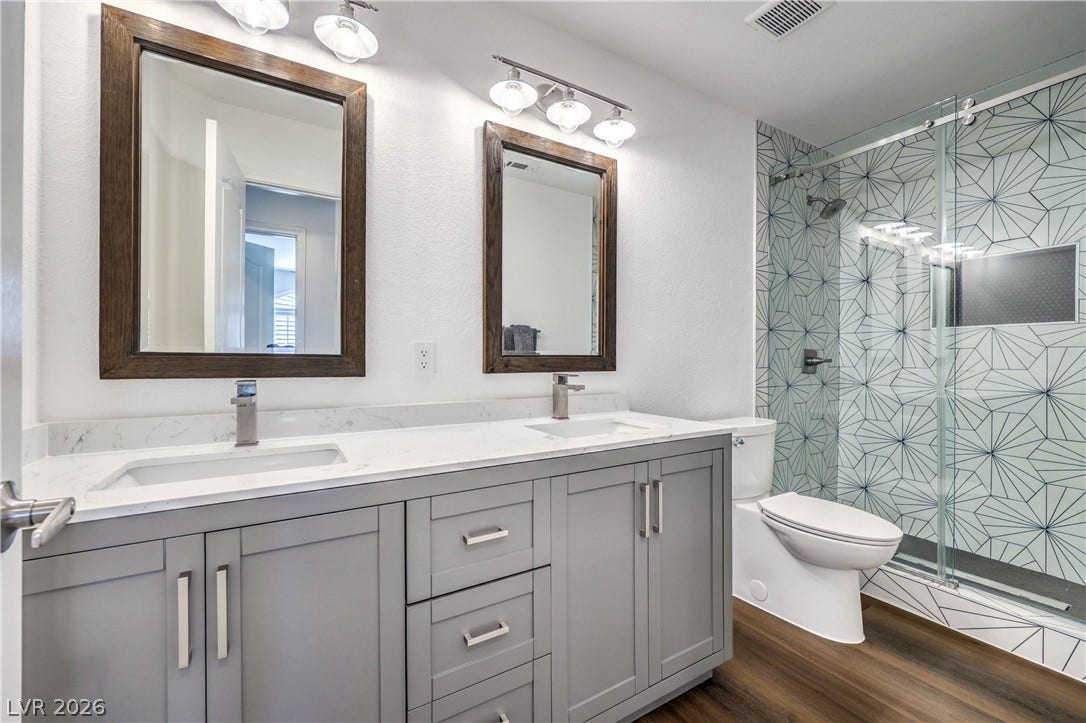 1863 Bogey Way, Henderson, NV 89074 Geometric accent tiles elevate a modern walk-in shower alongside a spacious double vanity.