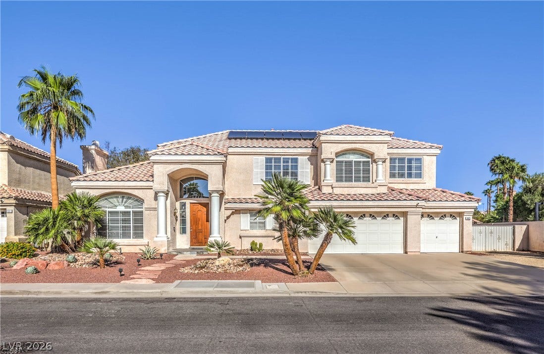 1863 Bogey Way, Henderson, NV 89074 Mediterranean-inspired architecture showcases classic columns, a tiled roof, and pristine desert landscaping.