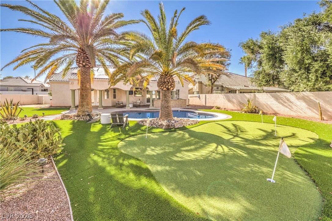 1863 Bogey Way, Henderson, NV 89074 Mature palm trees and a putting green frame the refreshing backyard swimming pool.