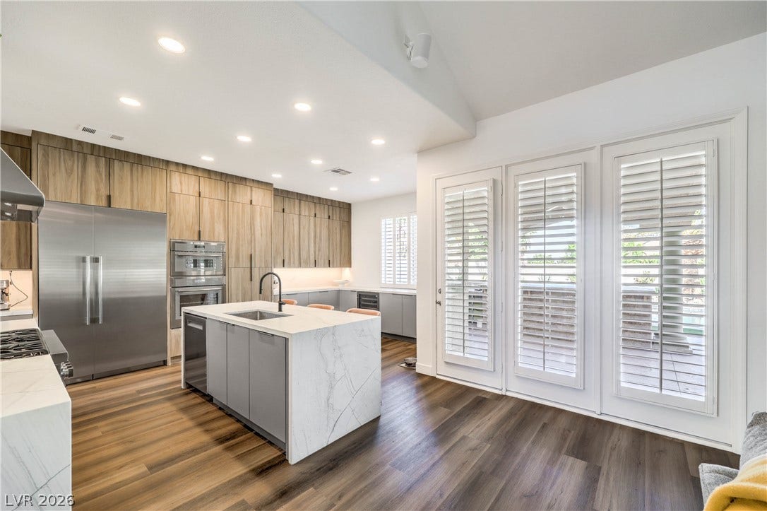 1863 Bogey Way, Henderson, NV 89074 Rich wood floors and sleek stone counters define this modern, sunlit kitchen.