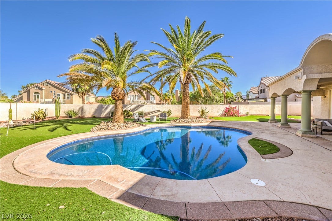 1863 Bogey Way, Henderson, NV 89074 Soaring palm trees frame a sparkling pool surrounded by a spacious concrete patio.