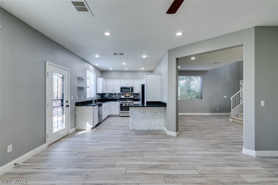 An open floorplan seamlessly connects the airy kitchen to adjacent living spaces.