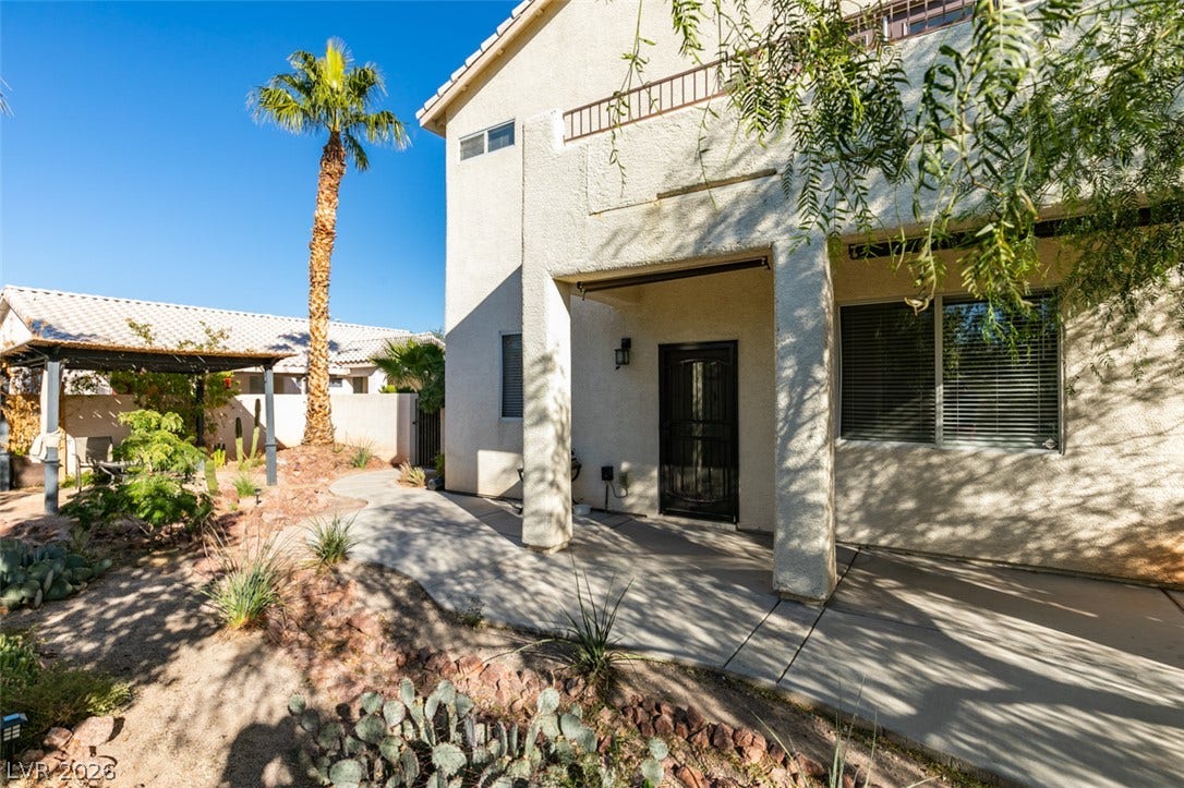 Desert landscaping and a covered concrete patio define this inviting two-story home's backyard space.