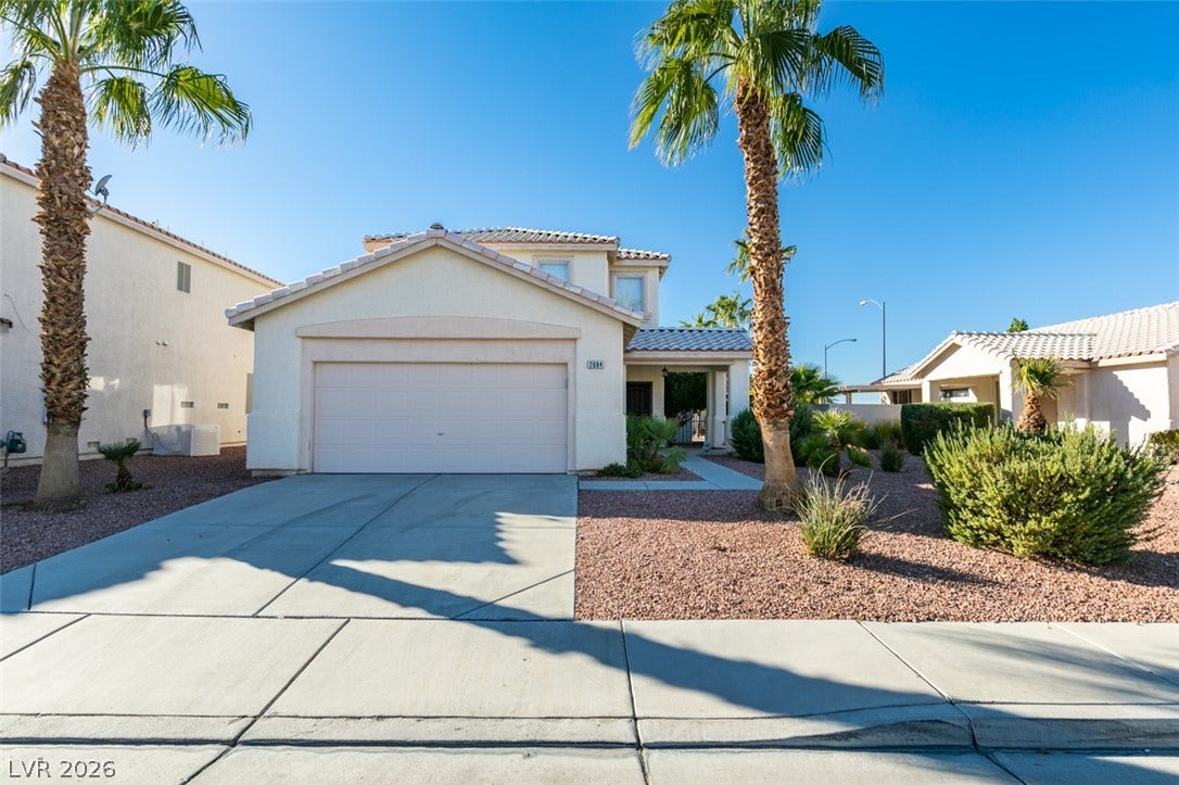 Stately palm trees frame the exterior of this two-level home with tile roof.
