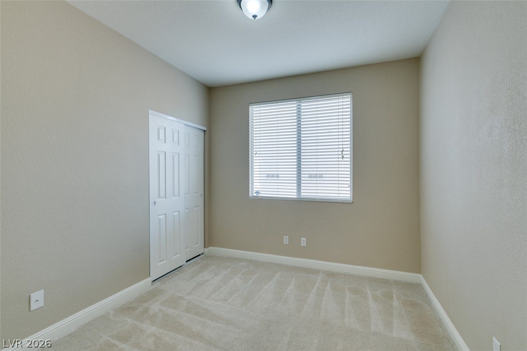 Soft carpeting pairs with neutral walls and abundant natural light in this versatile bedroom.