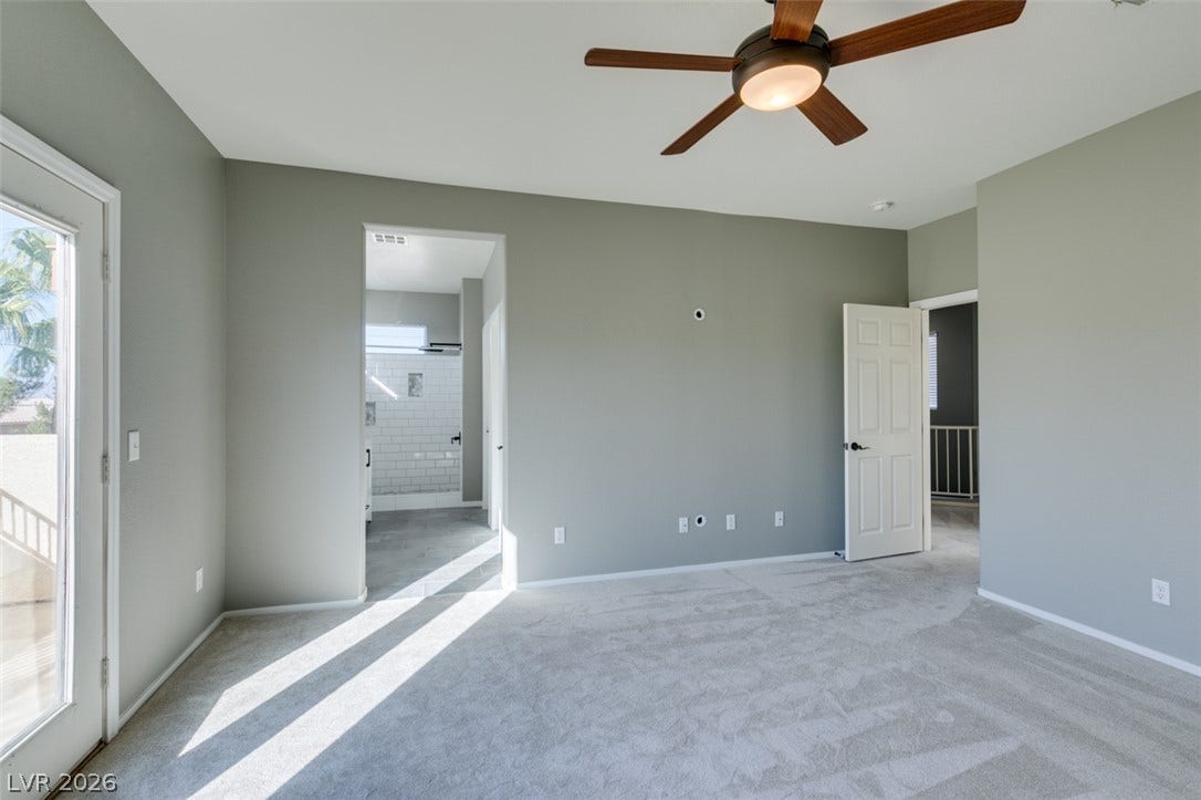 Plush carpeting and an attached bathroom create a comfortable primary bedroom suite.