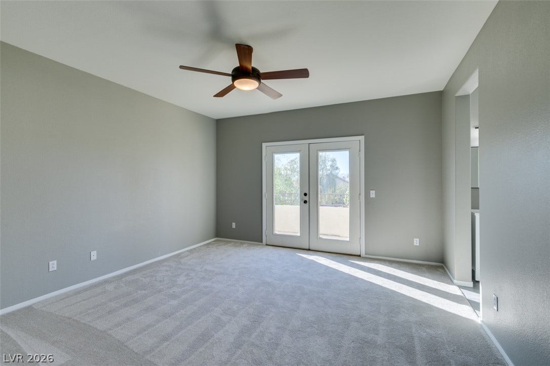 Double doors open to the outdoors in this light-filled room with plush carpeting.