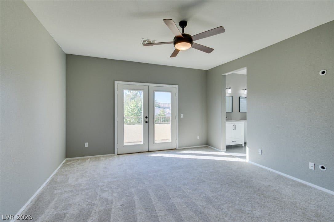 Double glass doors open to a private balcony from this spacious carpeted suite.