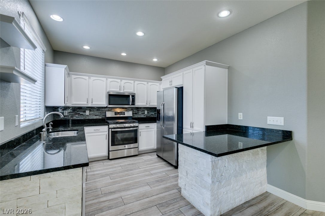 Gleaming stone countertops and stainless steel appliances complete this updated kitchen space.