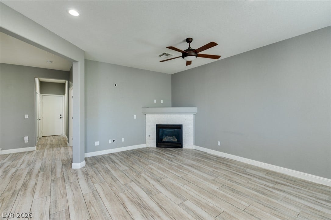 A corner fireplace and plank-style flooring anchor this open living area.