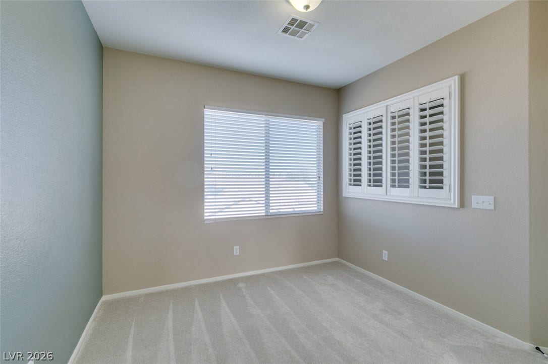 Plentiful natural light streams through multiple windows in this comfortable carpeted space.