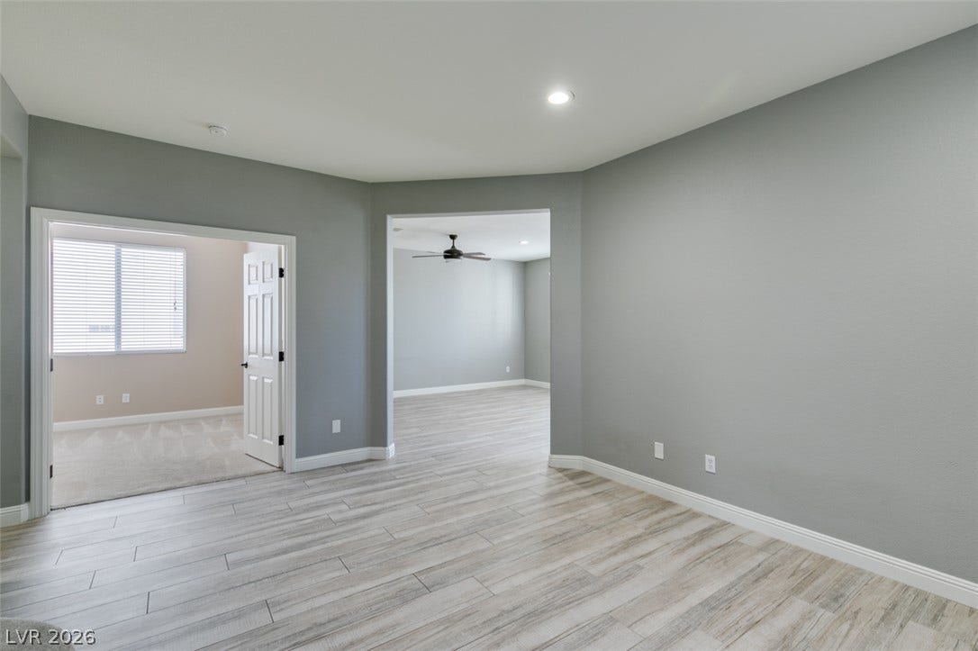 Clean lines and a spacious open layout connect versatile living areas with modern wood-look tile flooring.