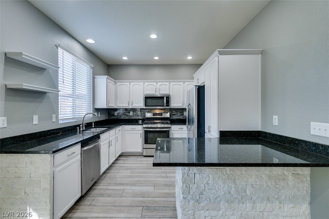 Granite countertops and crisp white cabinetry define this beautifully updated modern kitchen.