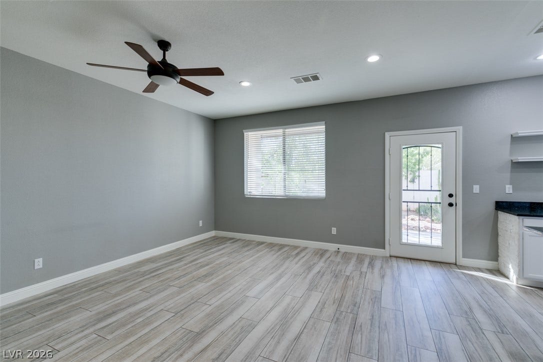 Gleaming wood-look tile flooring and recessed lighting define this versatile open living space.