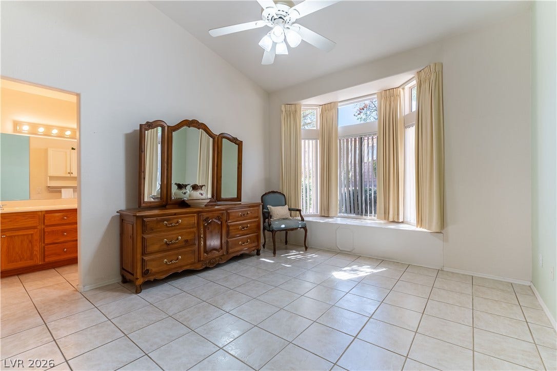 10005 Arbuckle Drive, Las Vegas, NV 89134 Tiled flooring and a vaulted ceiling define this main suite bedroom with a bay window.