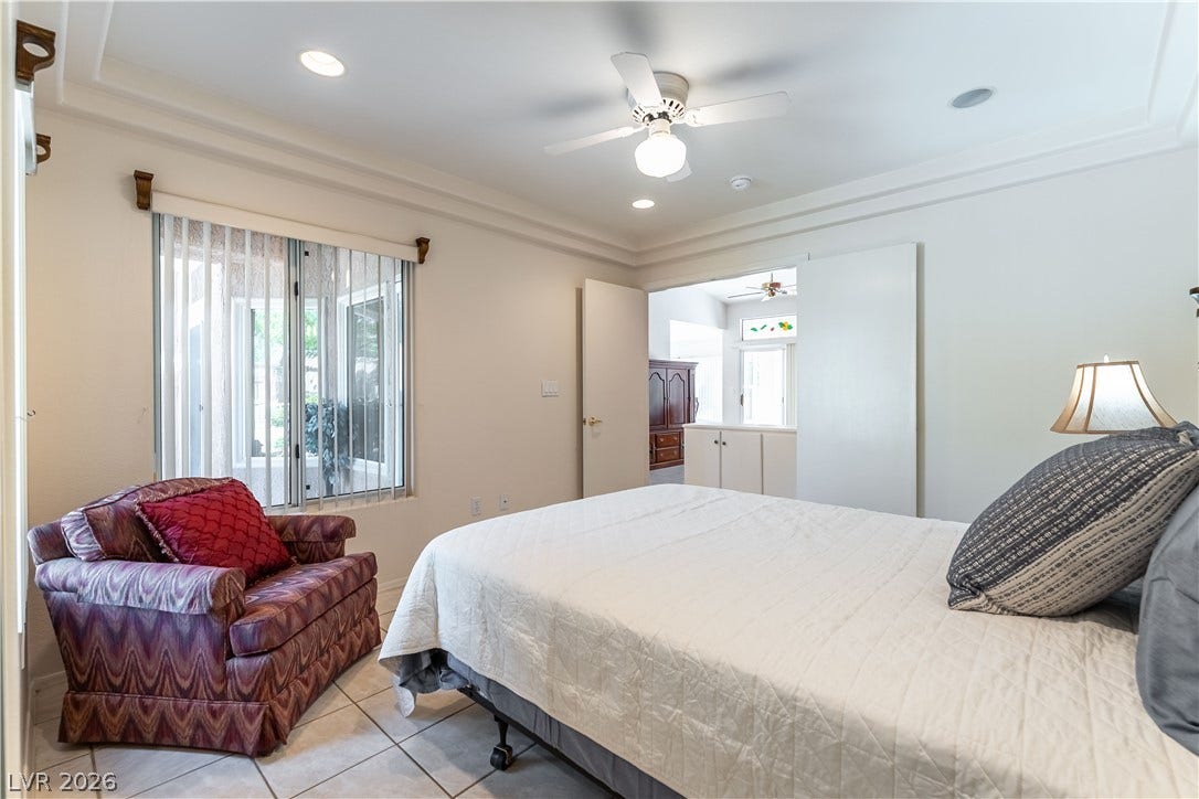10005 Arbuckle Drive, Las Vegas, NV 89134 Tiled flooring and elegant tray ceilings define this welcoming bedroom space.