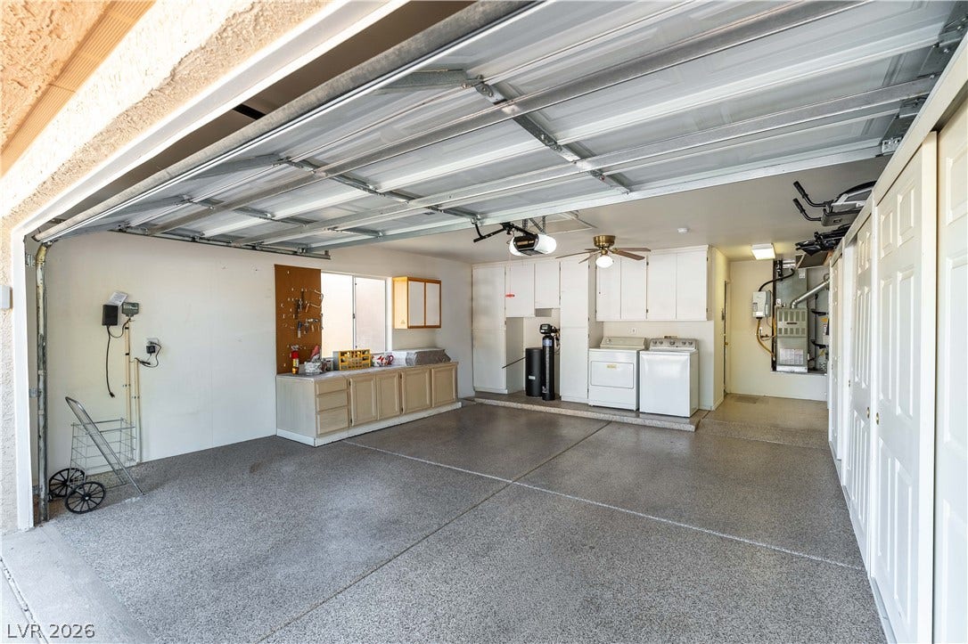 10005 Arbuckle Drive, Las Vegas, NV 89134 A spacious garage features durable concrete flooring and integrated storage cabinets.