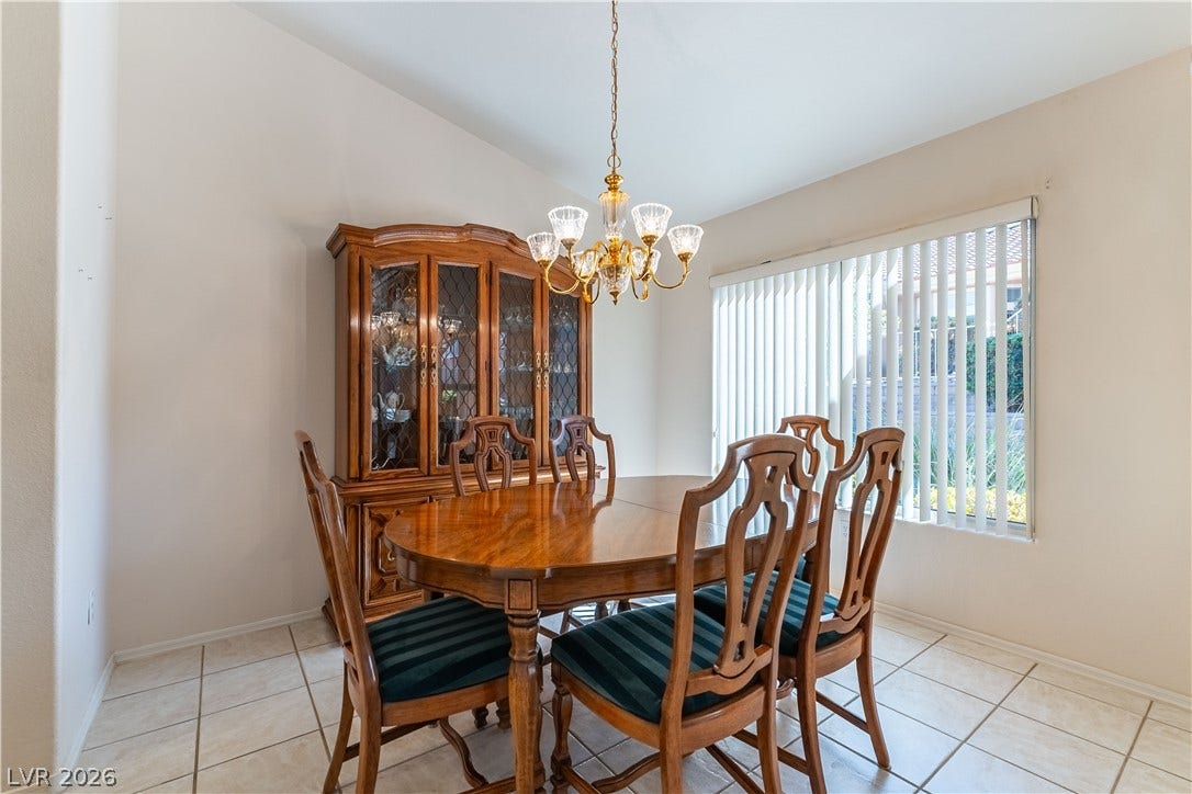 10005 Arbuckle Drive, Las Vegas, NV 89134 Tiled flooring and a wide window with vertical blinds anchor this bright dining space.