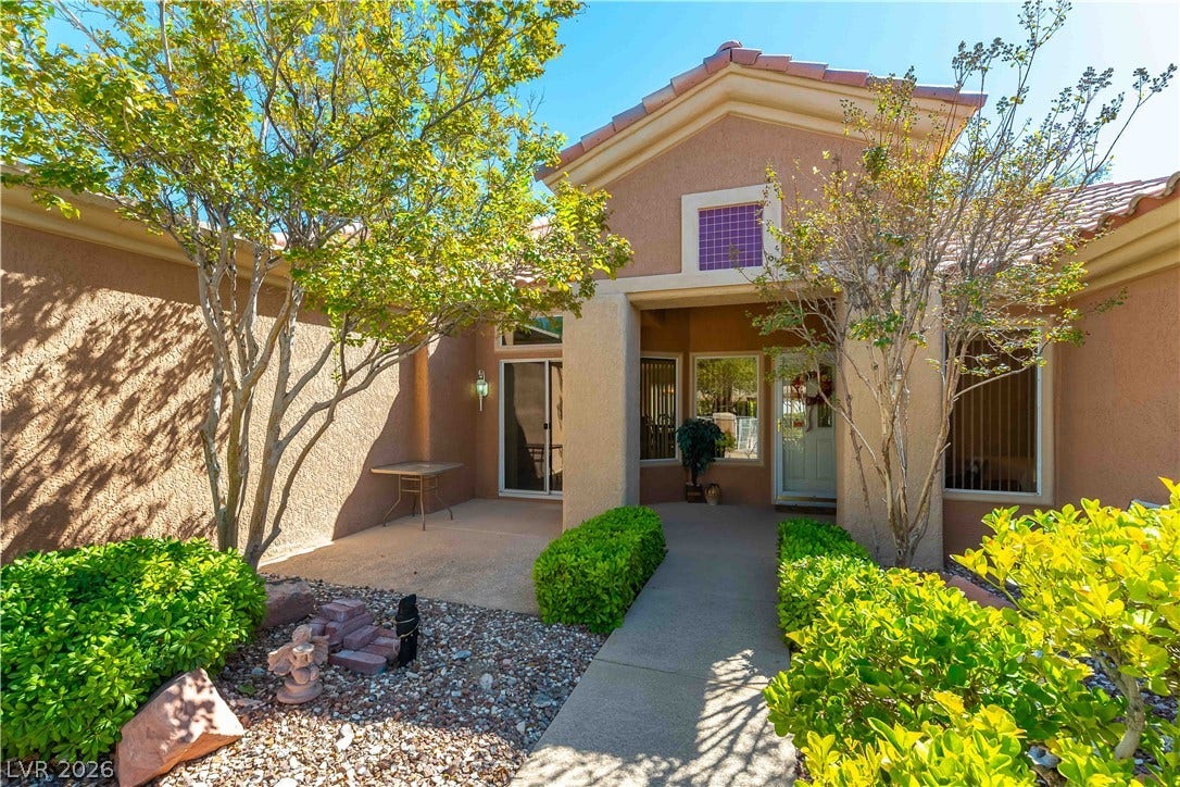 10005 Arbuckle Drive, Las Vegas, NV 89134 Manicured hedges flank a concrete walkway leading to the stucco home's inviting entryway.