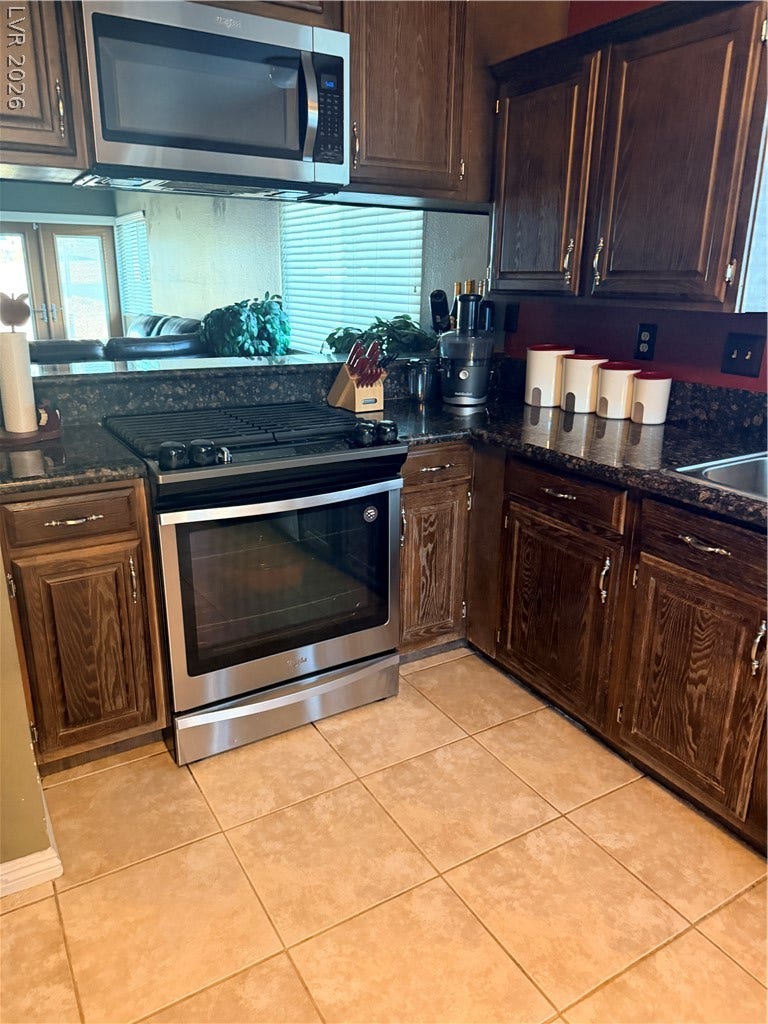 3126 Belvedere Drive, Henderson, NV 89014 Rich wood cabinetry pairs beautifully with tile flooring in this classic kitchen design.
