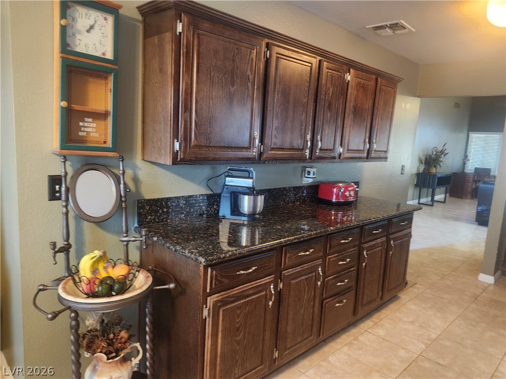 3126 Belvedere Drive, Henderson, NV 89014 Rich wood cabinets and polished granite counters anchor this functional workspace.