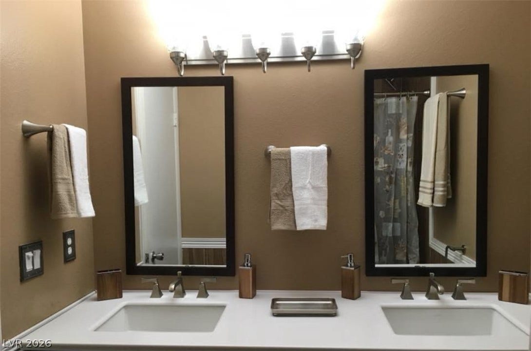 3126 Belvedere Drive, Henderson, NV 89014 Dual undermount sinks integrate seamlessly with the clean countertop and classic framed mirrors.