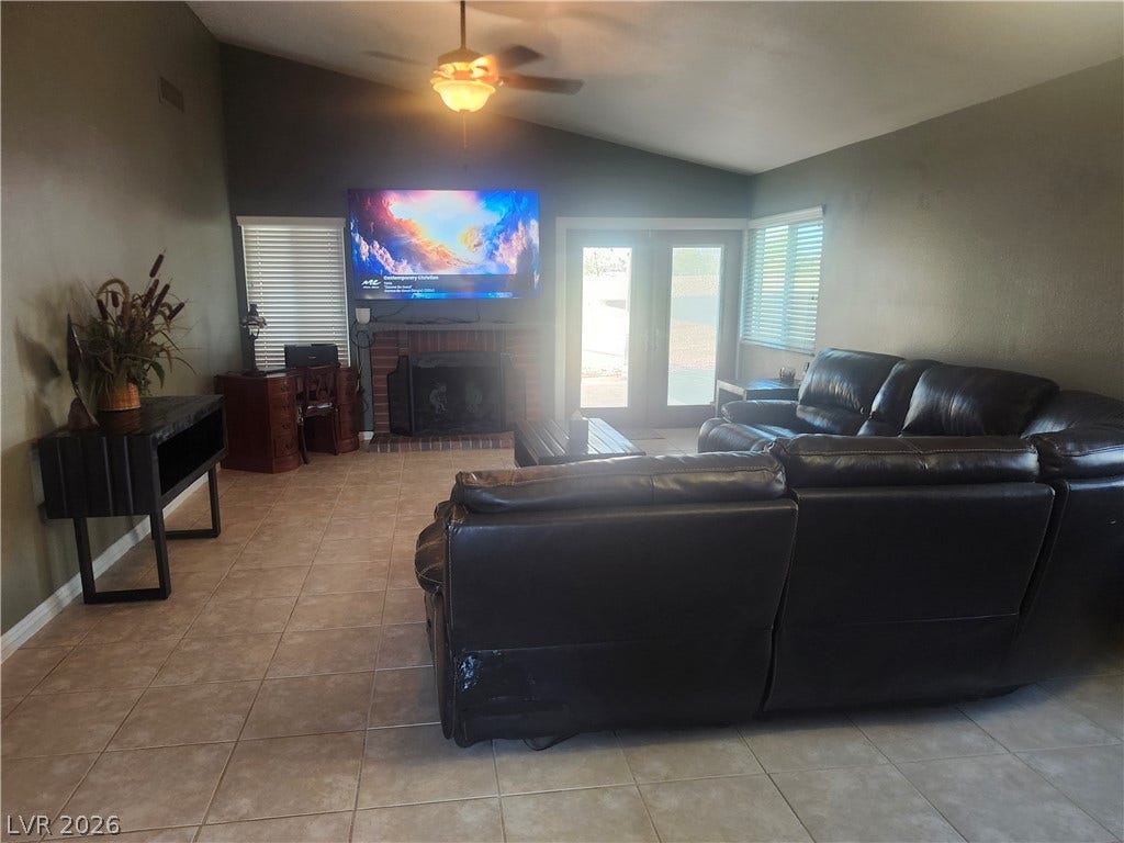 3126 Belvedere Drive, Henderson, NV 89014 A brick-clad fireplace anchors the living space, beneath high vaulted ceilings and tile flooring.