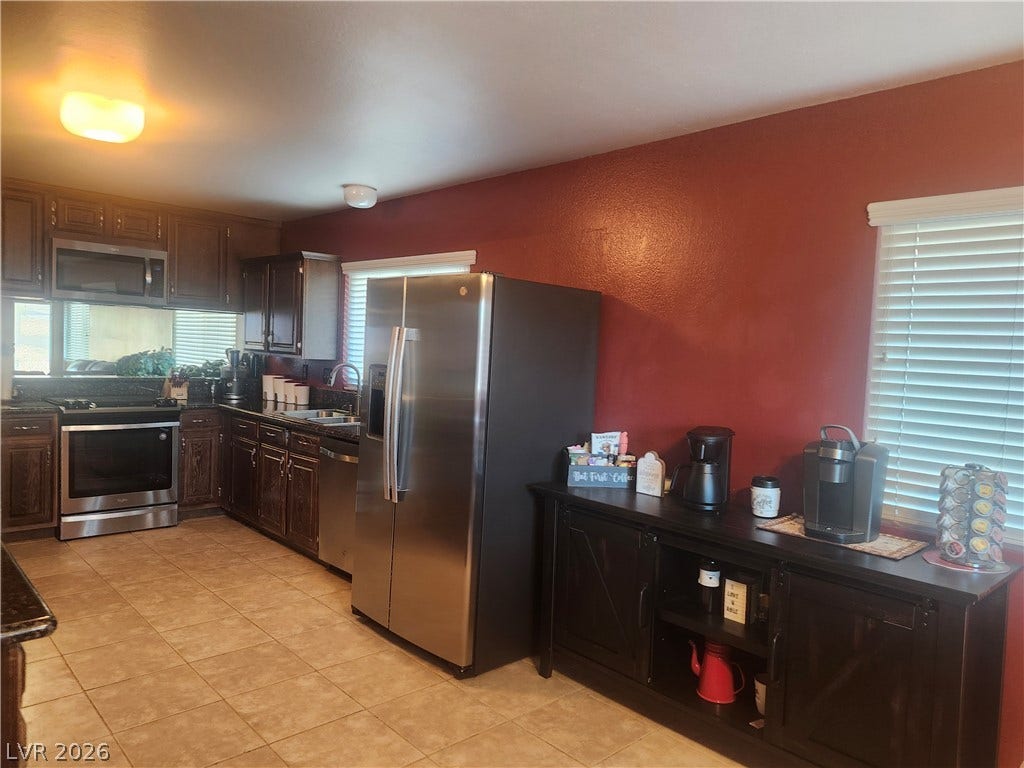 3126 Belvedere Drive, Henderson, NV 89014 Richly toned cabinetry and durable tile flooring define this functional culinary space.