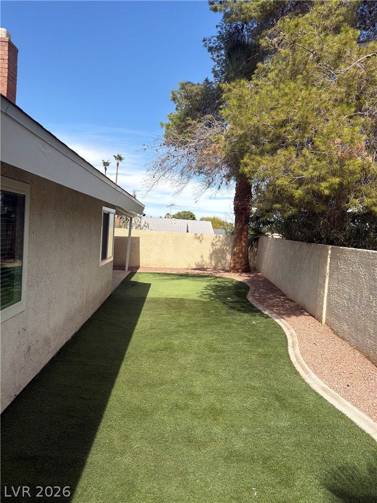 3126 Belvedere Drive, Henderson, NV 89014 An expansive side yard features a lush green lawn bordered by a block wall.