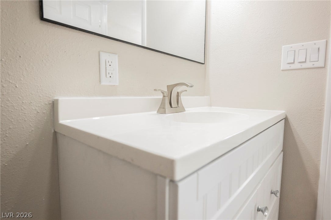 601 Sandy Drive, Henderson, NV 89002 Modern hardware and a clean white vanity highlight this updated powder room design.