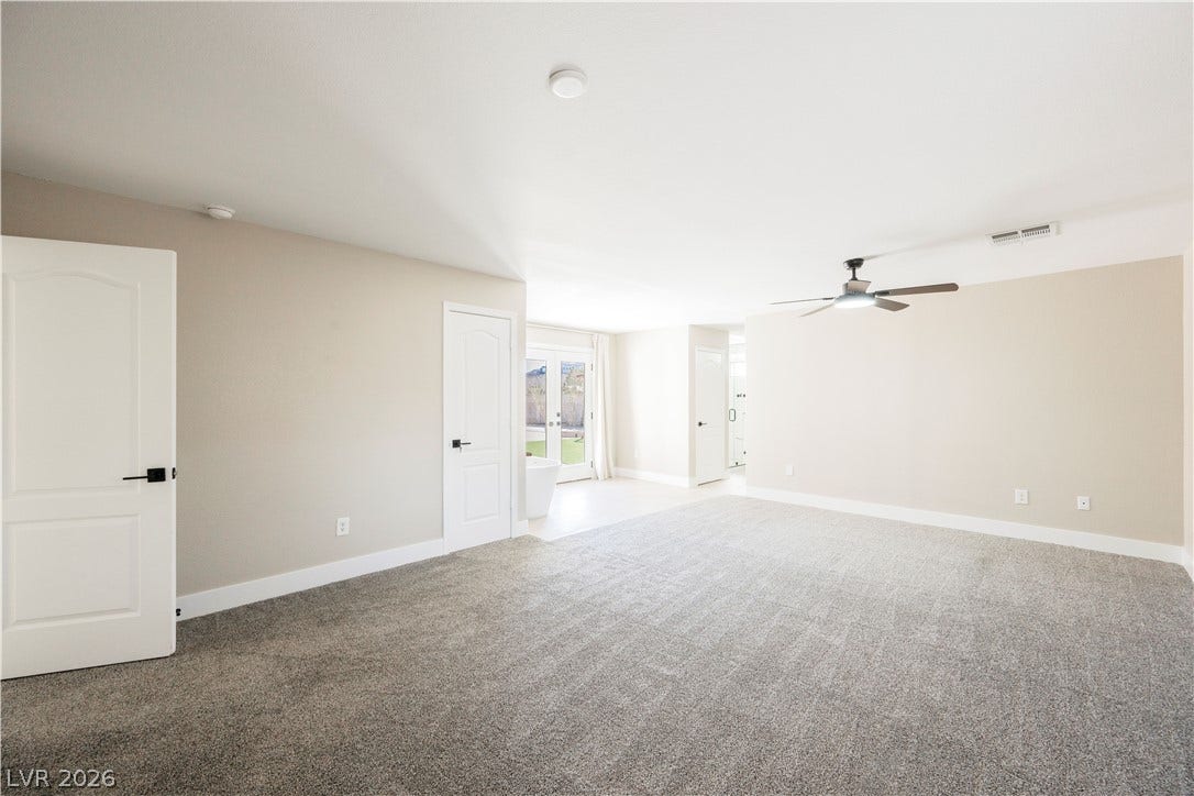 601 Sandy Drive, Henderson, NV 89002 An open and carpeted primary bedroom layout transitions smoothly into an adjacent bath suite.