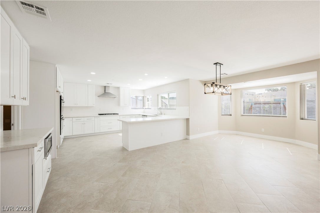 601 Sandy Drive, Henderson, NV 89002 Stone counters and tile flooring accent this open kitchen and dining area.