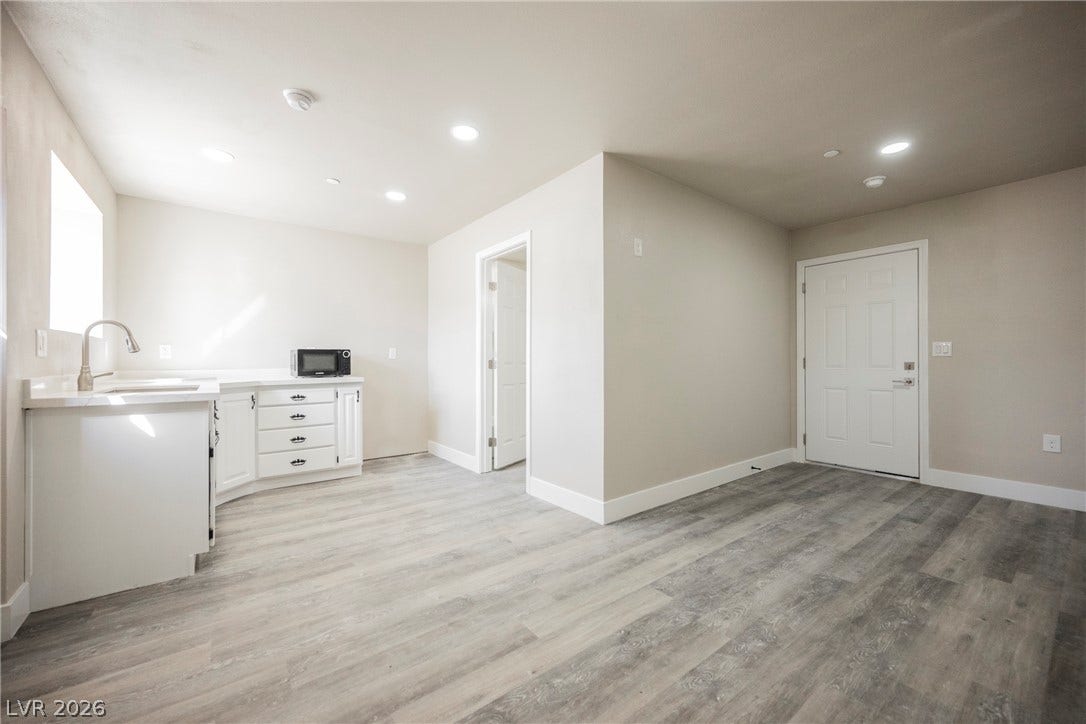 601 Sandy Drive, Henderson, NV 89002 Recessed lighting illuminates this versatile open layout featuring modern plank flooring and crisp white cabinetry.