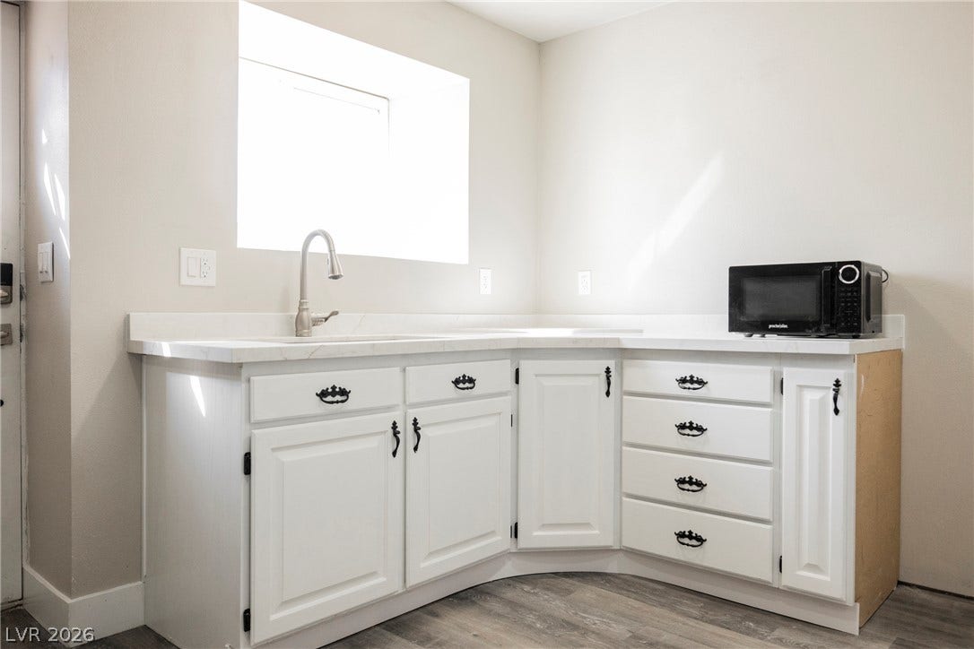 601 Sandy Drive, Henderson, NV 89002 Natural light pours over a functional wet bar featuring stone counters and vinyl plank flooring.