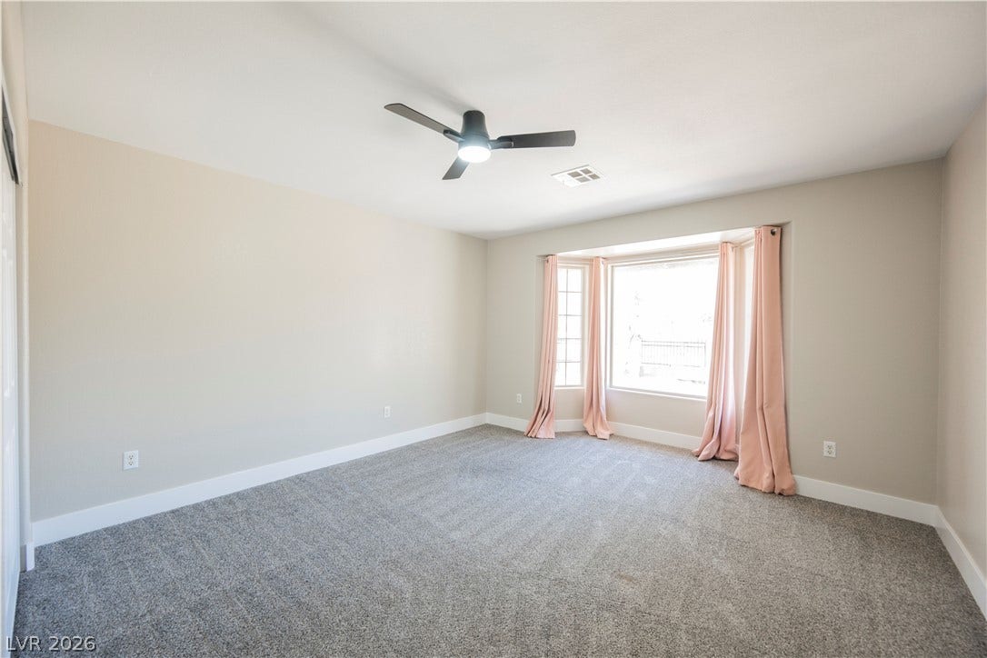 601 Sandy Drive, Henderson, NV 89002 A spacious bedroom features neutral walls, plush carpeting, and a large bay window.