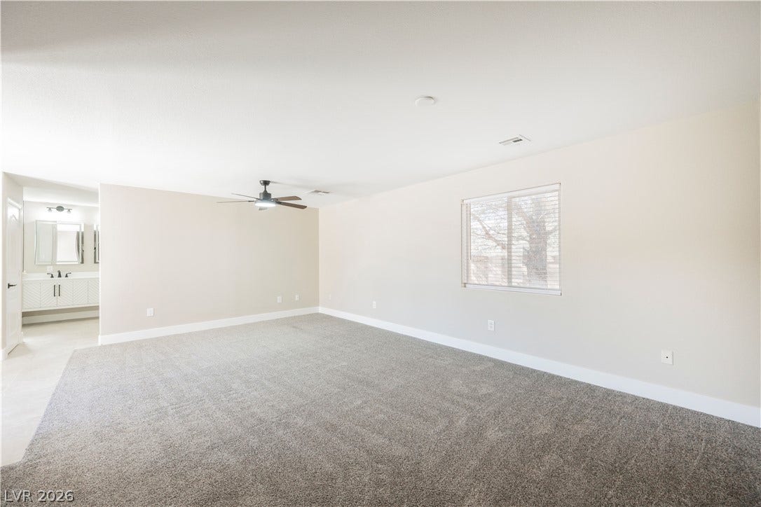 601 Sandy Drive, Henderson, NV 89002 An open bedroom layout features wall-to-wall carpeting and connects directly to a private bathroom.