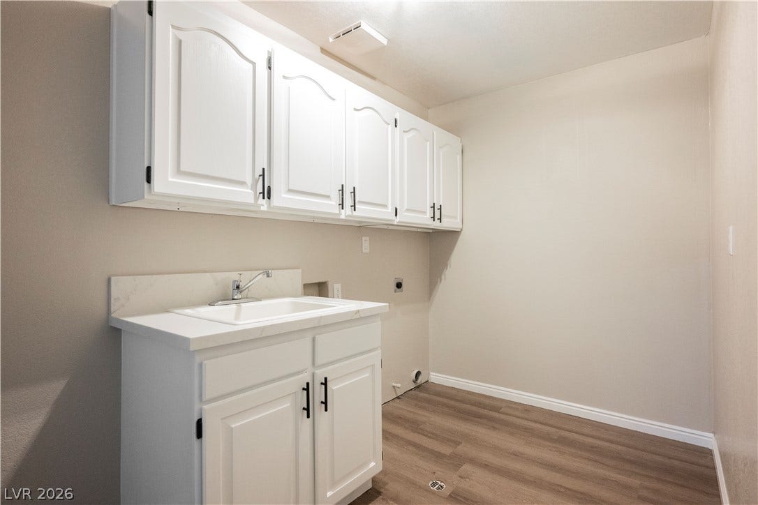 601 Sandy Drive, Henderson, NV 89002 Ample white cabinetry and a utility sink highlight this functional laundry space.