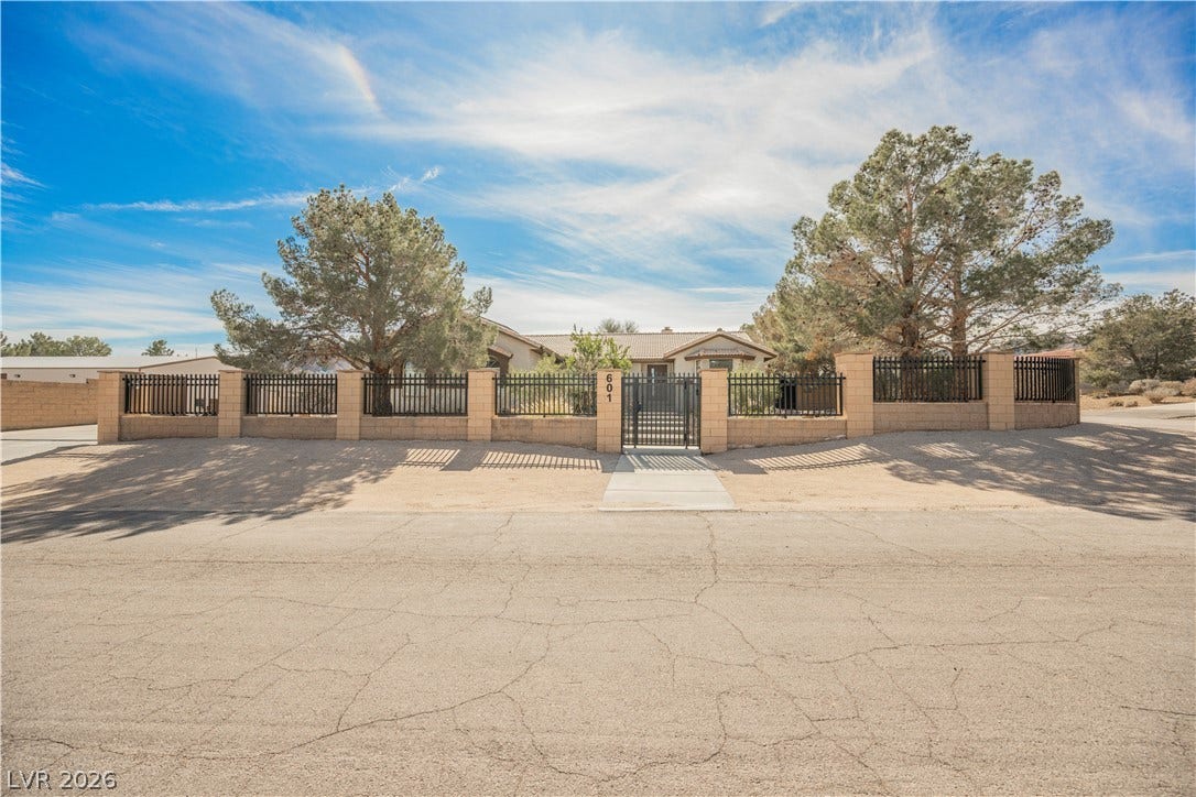 601 Sandy Drive, Henderson, NV 89002 A gated perimeter wall frames the desert landscape surrounding this single-story residence.