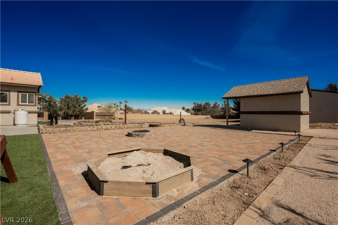 601 Sandy Drive, Henderson, NV 89002 A spacious paved patio features a built-in fire pit beneath wide open desert skies.