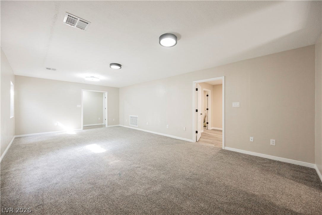 601 Sandy Drive, Henderson, NV 89002 An open and flexible room features plush carpeting and clean neutral walls.