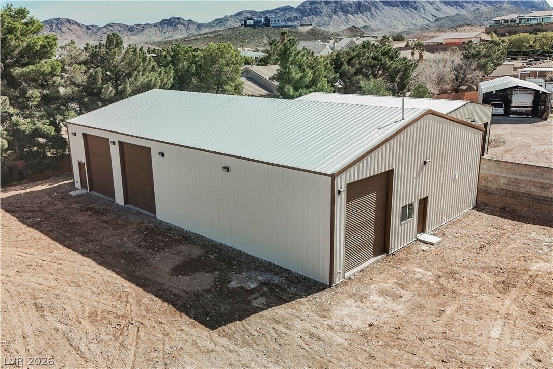 601 Sandy Drive, Henderson, NV 89002 A spacious detached metal workshop features multiple roll-up garage doors set against mountain views.