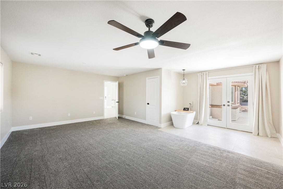 601 Sandy Drive, Henderson, NV 89002 Double doors open to the patio from this generous bedroom featuring an integrated tub.